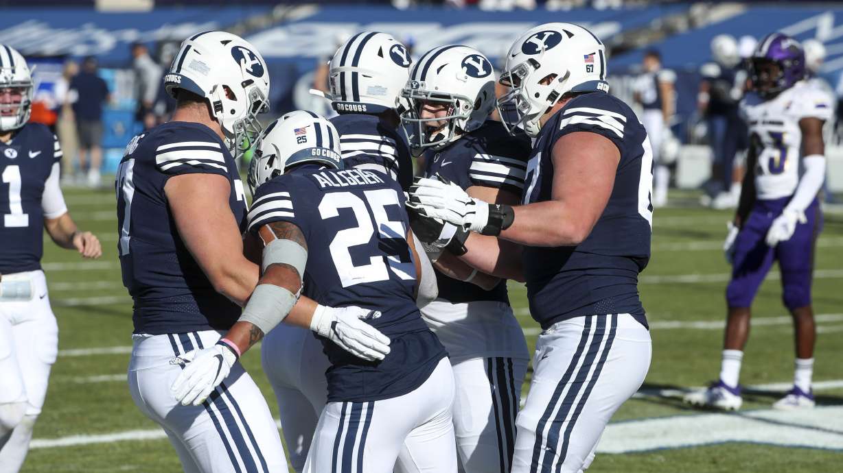 Brigham Young Cougars running back Tyler Allgeier (25) is congratulated by the BYU offensive line after scoring a touchdown during a game against North Alabama in Provo on Saturday, Nov. 21, 2020.