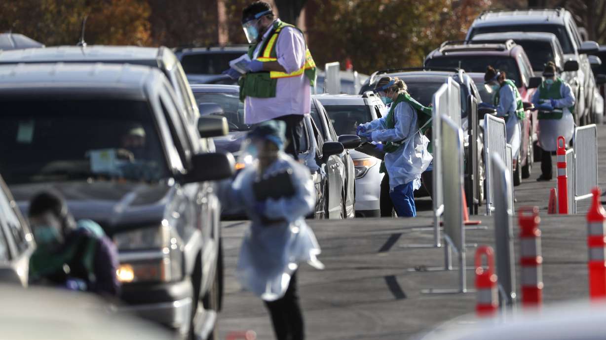 Salt Lake County mobile testers gather information from people as they wait in long lines to get tested for COVID-19 at the countyâs testing site in the Maverik Center parking lot in West Valley City on Tuesday, Nov. 17, 2020.