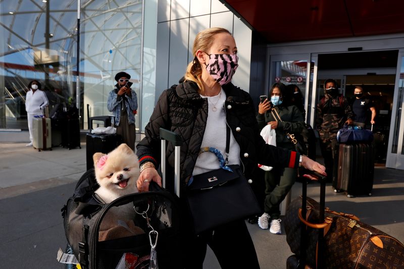 Stephanie Anderson and her companion, Gypsy, of Los Angeles, wait to depart Hartsfield-Jackson Atlanta International Airport ahead of the Thanksgiving holiday during the coronavirus disease (COVID-19) pandemic, in Atlanta, Georgia, U.S. November 23, 2020.