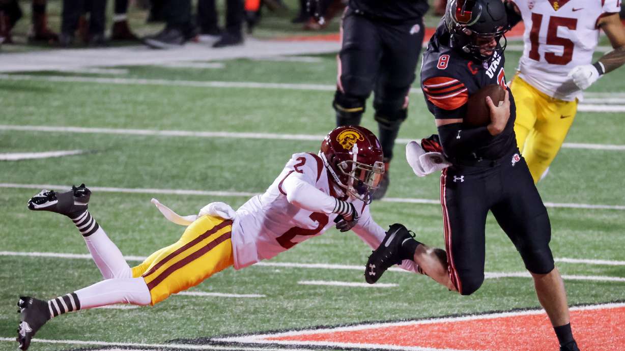 Utah Utes quarterback Jake Bentley (8) evades the tackle from USC Trojans cornerback Olaijah Griffin (2) at Rice-Eccles Stadium in Salt Lake City on Saturday, Nov. 21, 2020.