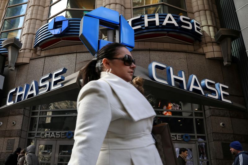 FILE PHOTO: A woman passes by a JPMorgan Chase bank in Times Square in New York City, U.S., March 7, 2019. REUTERS/Brendan McDermid