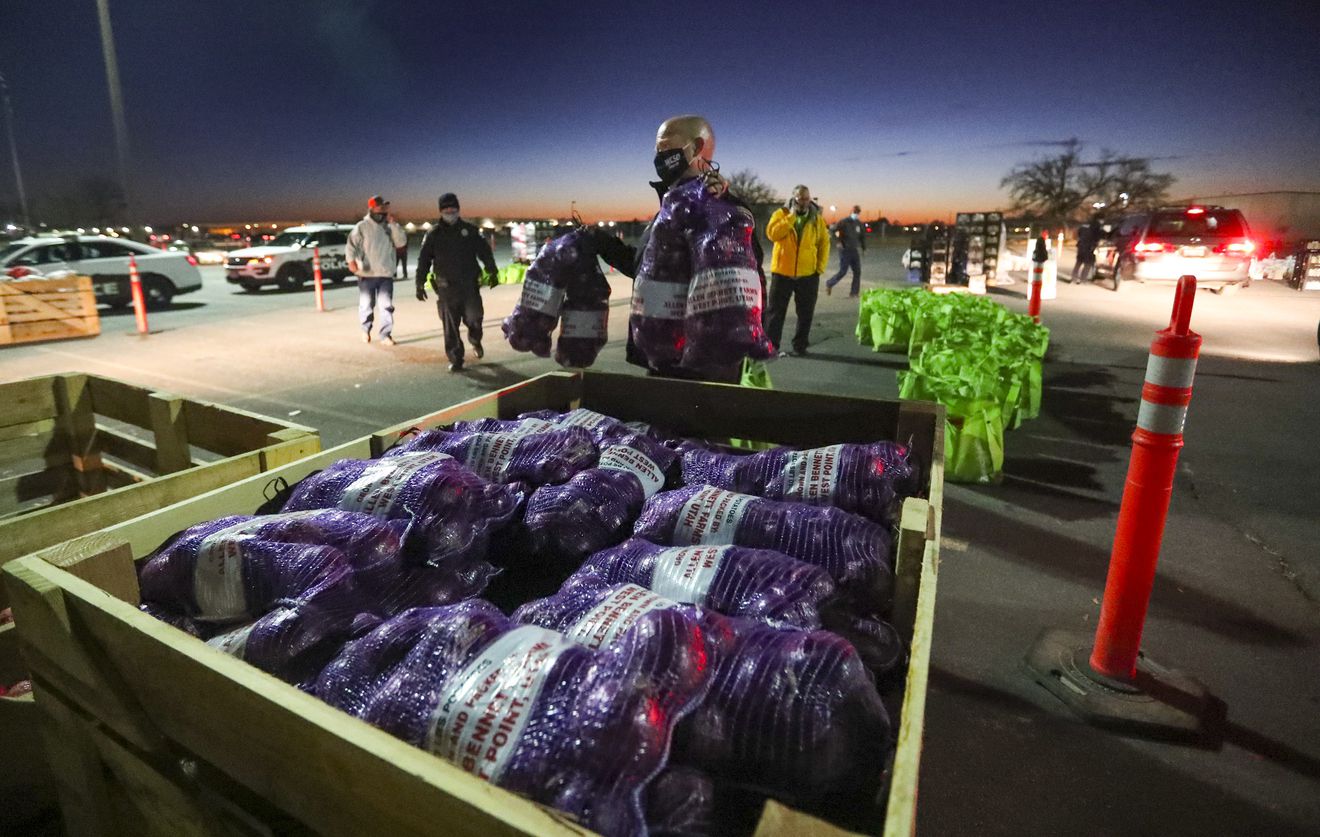 Weber County Sheriff Ryan Arbon carries onions to a vehicle as Weber County law enforcement officers and staff members distribute a Thanksgiving dinner to those in need during a “Cops & Crops” drive-thru event at the Weber County Fairgrounds in Ogden on Tuesday, Nov. 24, 2020.