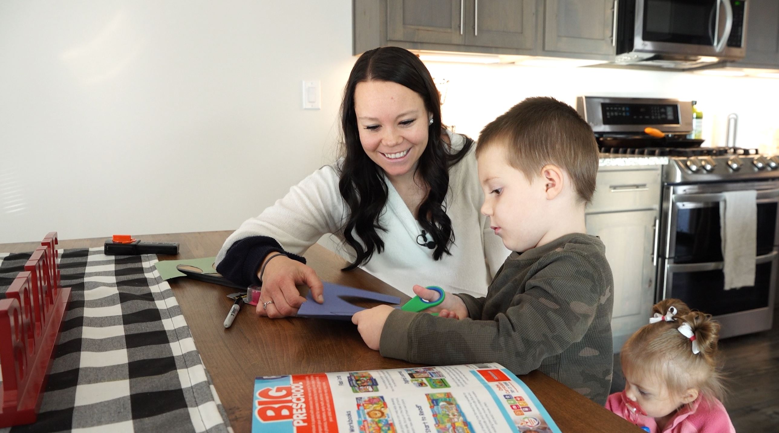 Kami Christensen helps her son, Jed, cut out paper turkey feathers so they can write down things he is grateful for.
