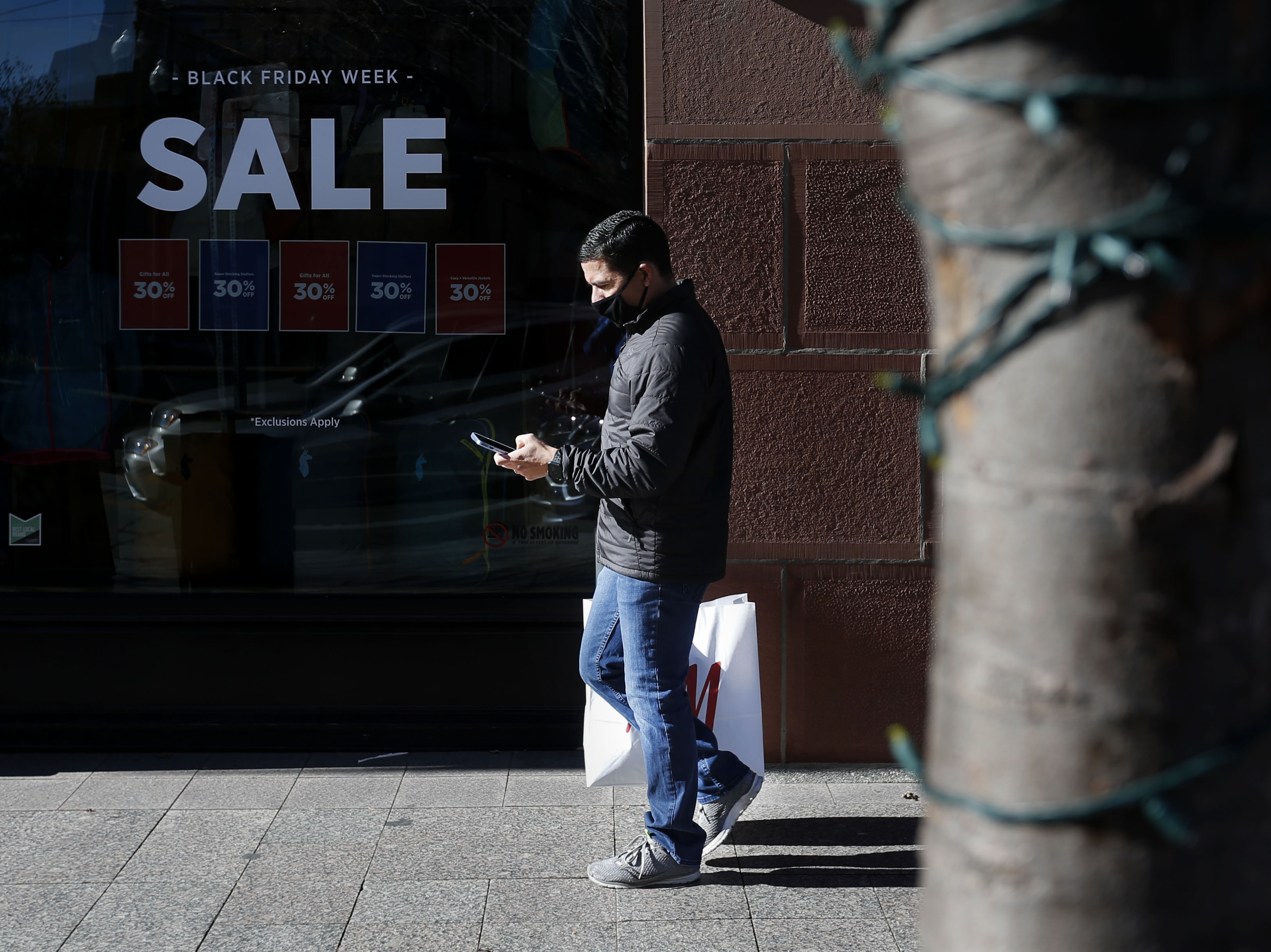 Roberto Gonzalez of Los Angeles walks down Main Street in Salt Lake City on an untraditionally quiet Black Friday, Nov. 27, 2020. Gonzalez said he enjoyed his shopping experience because he did not see people fighting over sale items as would be expected on a typical Black Friday.