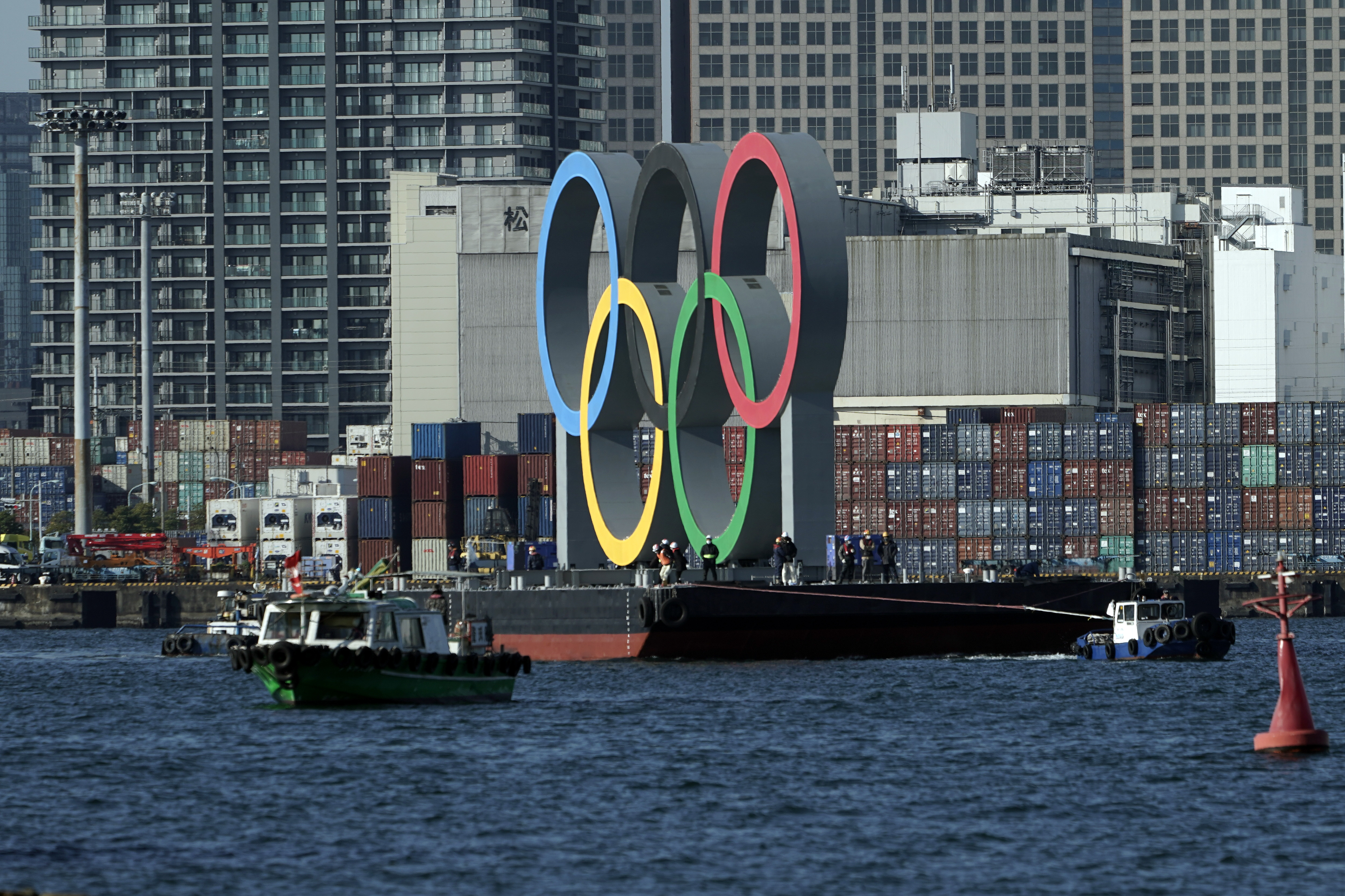 The Olympic Symbol is transported on a barge in the Odaiba section Tuesday, Dec. 1, 2020, in Tokyo. The five Olympic rings are back in Tokyo Bay. They were removed for maintenance four months ago shortly after the Tokyo Olympics were postponed until next year because of the COVID-19 pandemic.