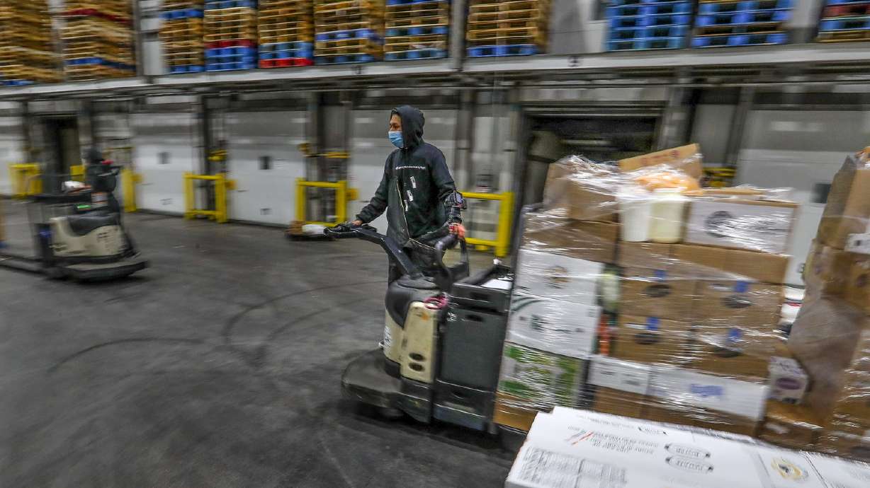 Saul Flores, a loader for Nicholas and Company, uses a forklift to load cold food into refrigerated trucks at the company’s warehouse in Salt Lake City on Tuesday, Dec. 1, 2020.
