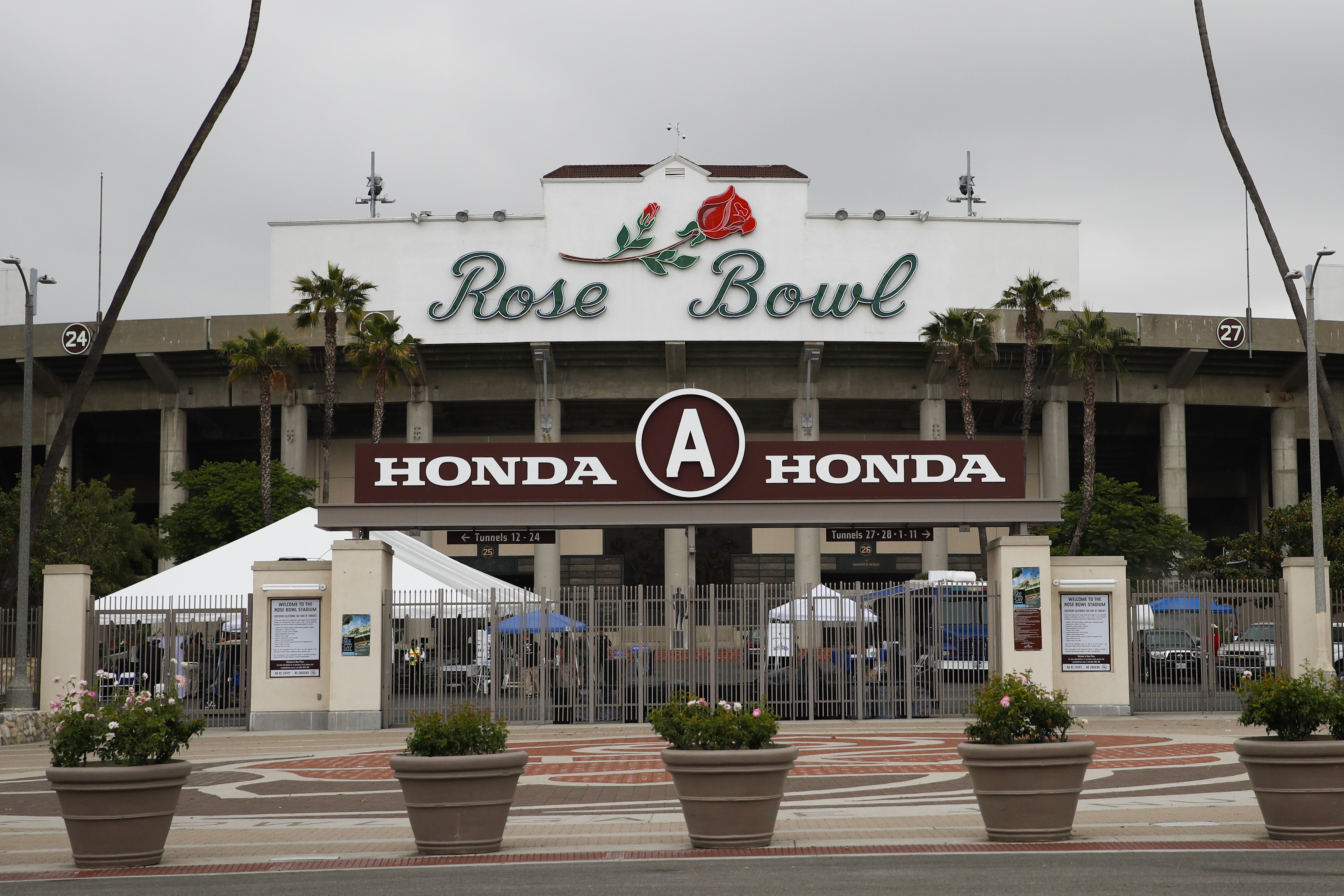Members of the media gather outside the Rose Bowl Stadium in Pasadena, Calif. No spectators will be allowed at the Rose Bowl for the College Football Playoff semifinal on Jan. 1 because of COVID-19 restrictions imposed by the state, county and city of Pasadena, The Tournament of Roses said Thursday, Dec. 3, 2020.