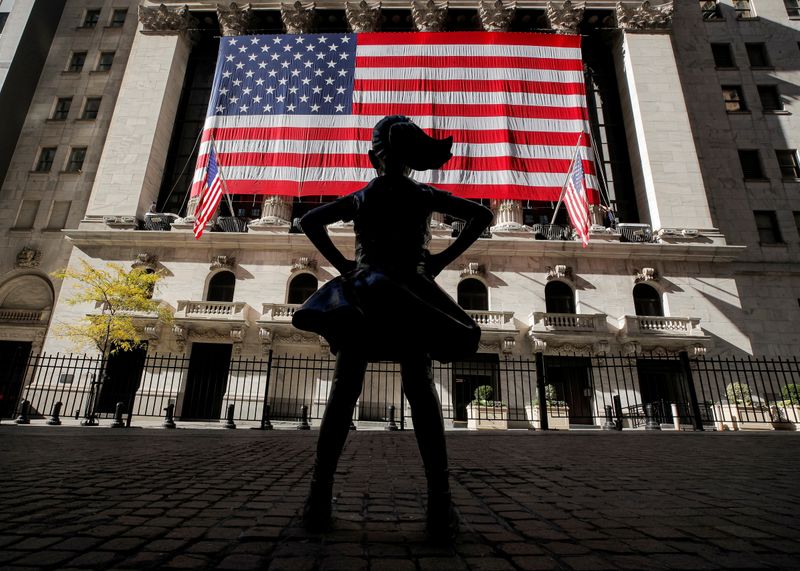 FILE PHOTO:  The Fearless Girl statue is seen as the  U.S. flag covers the front facade of the New York Stock Exchange (NYSE) in New York City, New York, U.S., November 9, 2020. REUTERS/Brendan McDermid/File Photo