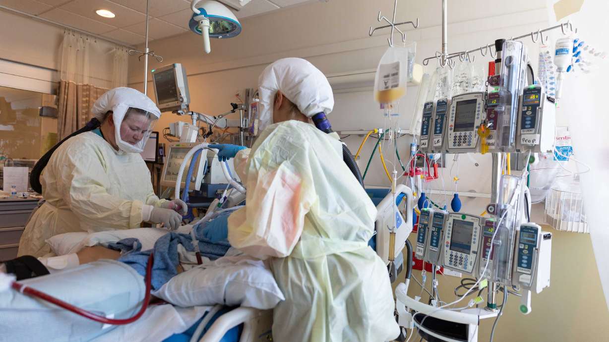 Healthcare workers care for a COVID-19 patient in the ICU at Intermountain Medical Center in Murray.