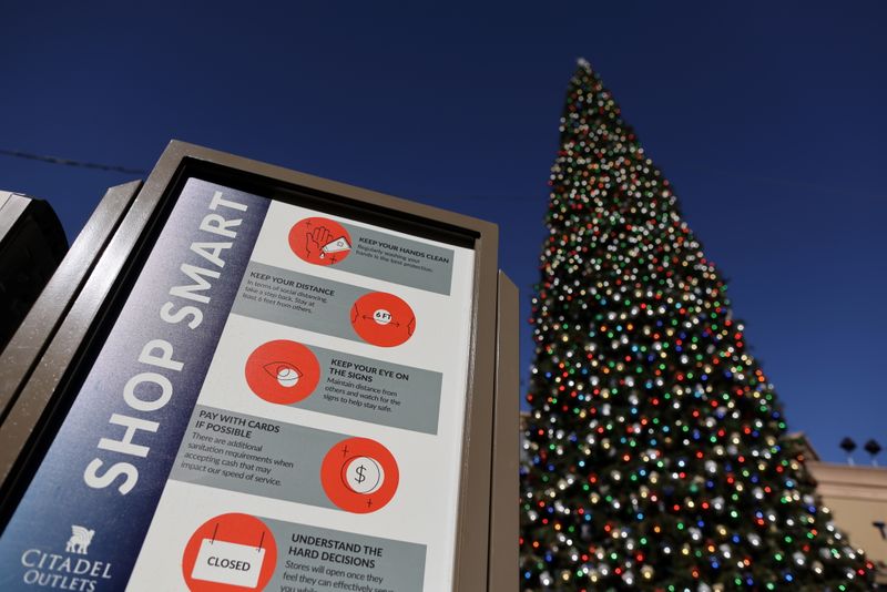 FILE PHOTO: A coronavirus advisory sign is seen in front of a Christmas tree at the Citadel Outlet mall, as the global outbreak of the coronavirus disease (COVID-19) continues, in Commerce, California, U.S., December 3, 2020. REUTERS/Lucy Nicholson