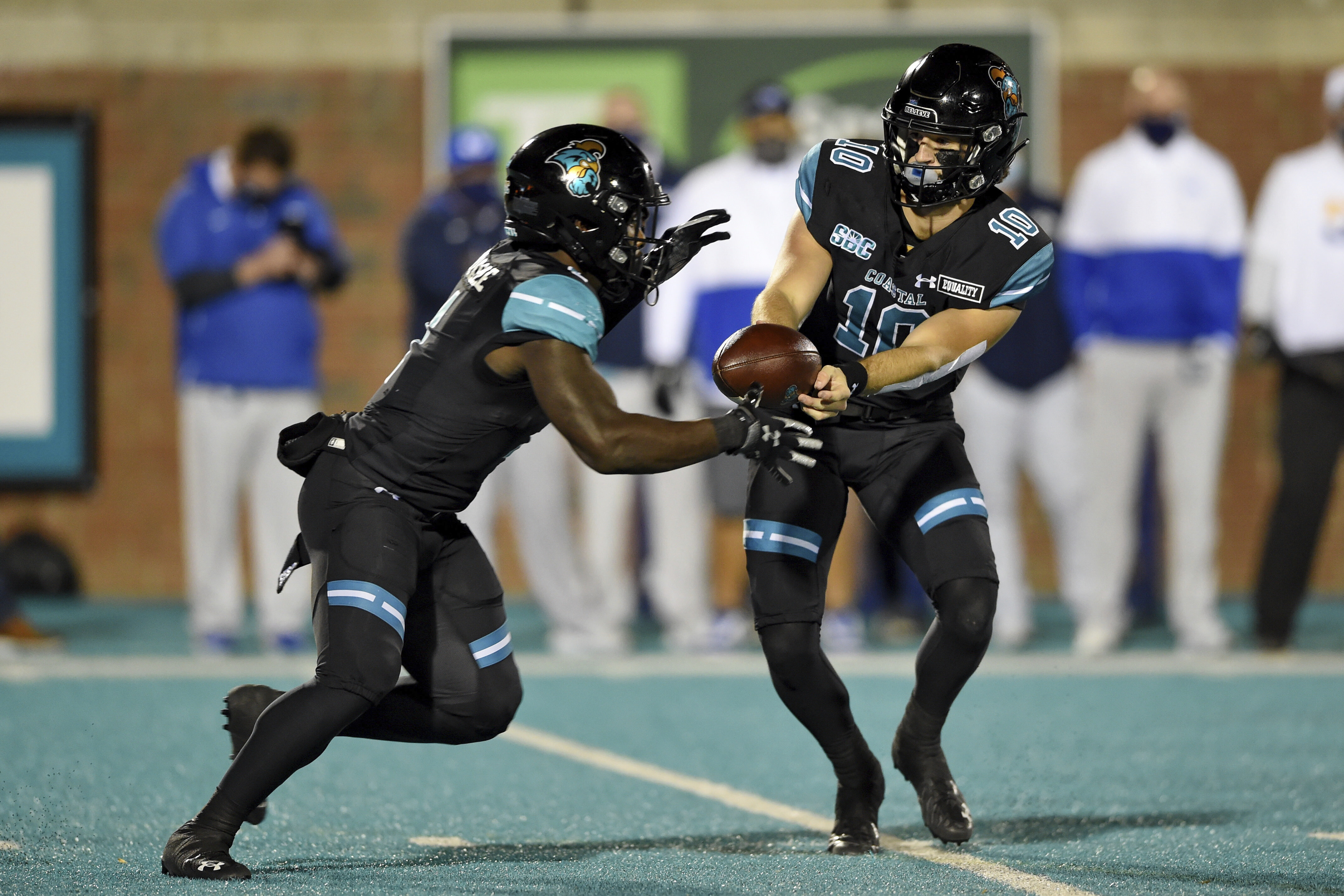 Coastal Carolina quarterback Grayson McCall, right, hands the ball off to CJ Marable during the first half of an NCAA college football game against BYU Saturday, Dec. 5, 2020, in Conway, S.C.