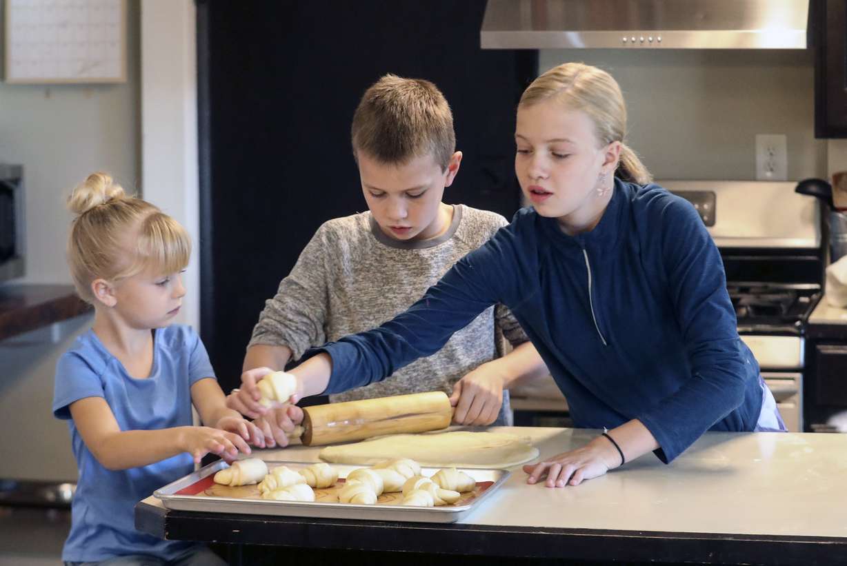 Penny, left, Henry and Ellie White make Thanksgiving rolls in the kitchen of their home in Holladay on Wednesday, Nov. 25, 2020. The family started a bakery two years ago and has been baking loaves of bread every week, fulfilling neighbors' orders. This year, the family is donating proceeds from Thanksgiving roll sales to foster care agency Brighter Futures to help pay for kids' Christmas presents after Utah and Salt Lake counties notified the agency they can't give it funding for gifts this year.