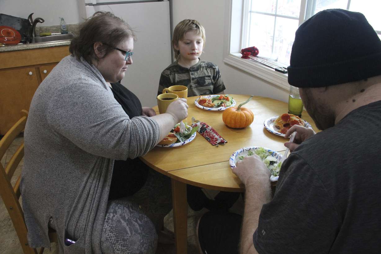 Airis Messick, left, and Brian Messick, right, eat lunch with their 9-year-old son, Jayden, at their apartment in Anchorage, Alaska, on Wednesday, Nov. 11, 2020.