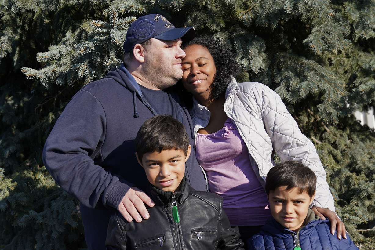 Aaron Crawford, his wife Sheyla and their sons, Sornic, left, and Gabriel, stand for a photograph outside their Apple Valley, Minn., home on Saturday, Nov. 21, 2020.