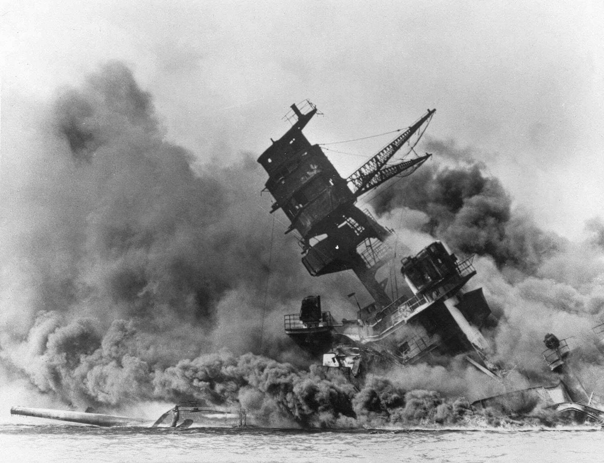 FILE - In this Dec. 7, 1941 file photo, smoke rises from the battleship USS Arizona as it sinks during a Japanese surprise attack on Pearl Harbor, Hawaii. The coronavirus pandemic is preventing Pearl Harbor survivors from attending an annual ceremony to remember those killed in the 1941 attack. The National Park Service and Navy also are closing the ceremony to the public and livestreaming it instead. (AP Photo, File) [Dec-07-2020]