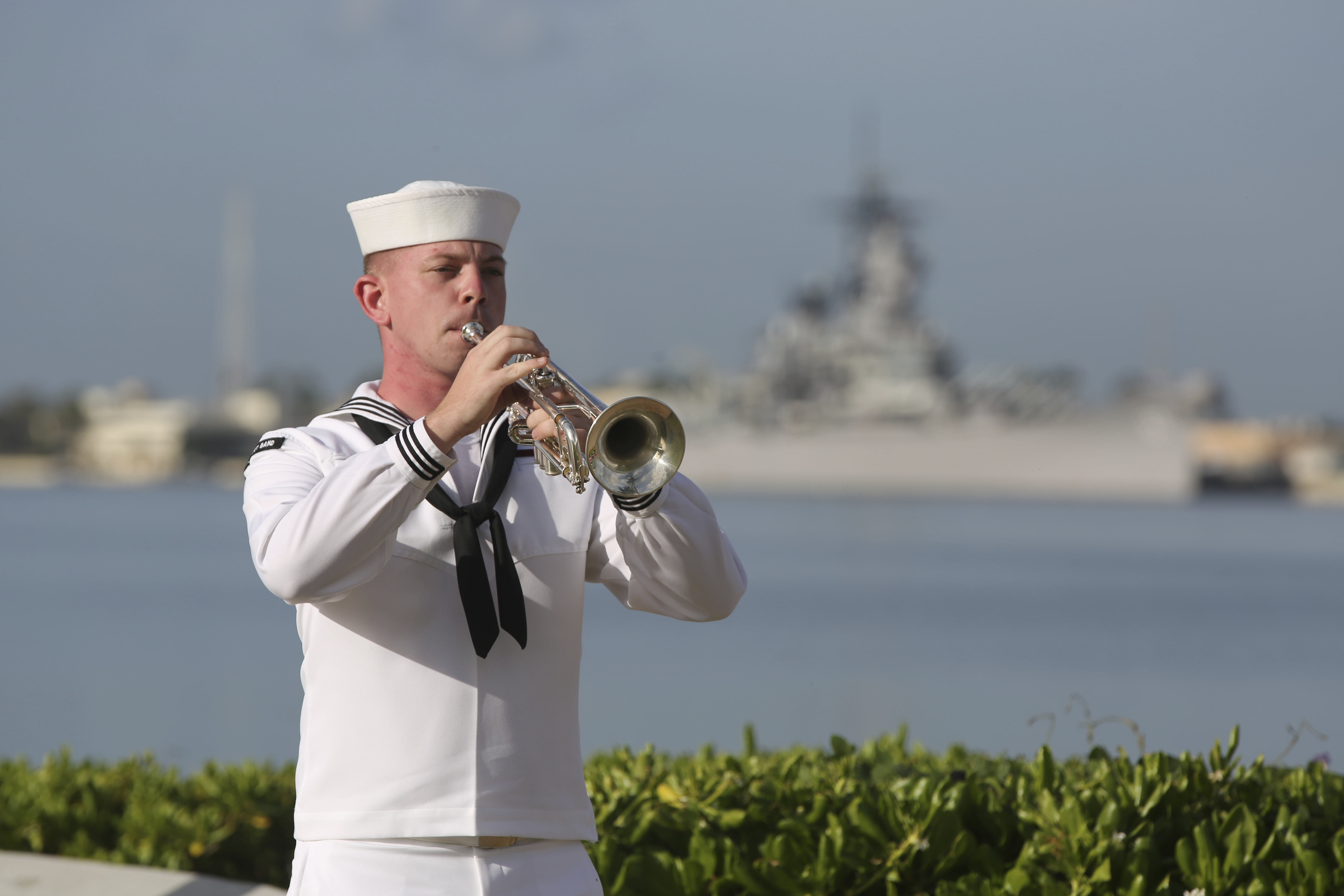 A U.S. Navy sailor plays taps in front of the USS Missouri during a ceremony to mark the anniversary of the attack on Pearl Harbor, Monday, Dec. 7, 2020, in Pearl Harbor, Hawaii. Officials gathered in Pearl Harbor to remember those killed in the 1941 Japanese attack, but public health measures adopted because of the coronavirus pandemic meant no survivors were present. The military broadcast video of the ceremony live online for survivors and members of the public to watch from afar. A moment of silence was held at 7:55 a.m., the same time the attack began 79 years ago. (AP Photo/Caleb Jones, Pool) [Dec-07-2020]