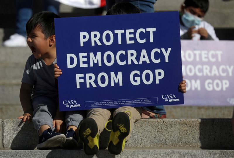 FILE PHOTO: Young supporters of Democratic candidate Joe Biden sit on the steps as supporters of U.S. President Donald Trump rally nearby outside of the State Capitol building after news media declared Joe Biden to be the winner of the 2020 U.S. presidential election, in Harrisburg, Pennsylvania, U.S., November 7, 2020. REUTERS/Leah Millis/File Photo