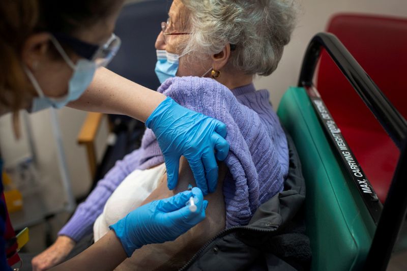 FILE PHOTO: A woman receives the first of two Pfizer/BioNTech COVID-19 vaccine jabs, at Guy's Hospital, at the start of the largest ever immunisation programme in the British history, in London, Britain December 8, 2020. Victoria Jones/Pool via REUTERS/File Photo
