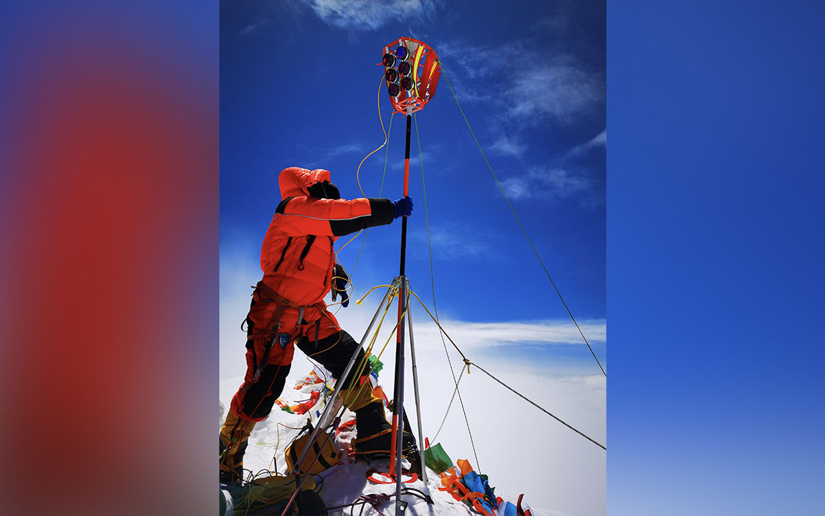 In this May 27, 2020, file photo released by Xinhua News Agency, a member of a Chinese surveying team sets up a survey equipment on the summit of Mount Everest also known locally as Mt. Qomolangma. China and Nepal have jointly announced on Tuesday, Dec. 8, 2020, a new height for Mount Everest, ending a discrepancy between the two nations.