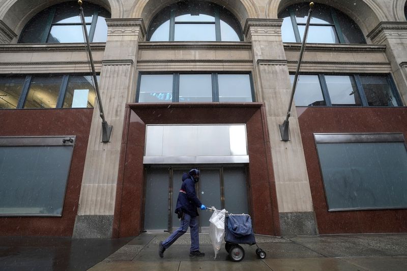 A postal employee walks past the Facebook office building during the coronavirus (COVID-19) pandemic in the Manhattan borough of New York City, New York, U.S., December 9, 2020. REUTERS/Carlo Allegri
