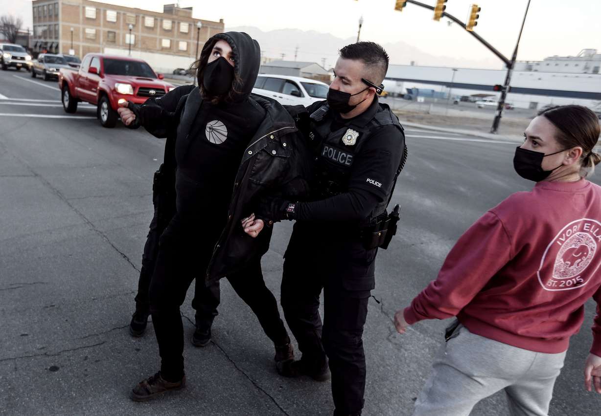 A protester is detained by Salt Lake police officers during a clash over the Salt Lake County Health Department’s efforts to clean up homeless encampments in Salt Lake City on Wednesday, Dec. 9, 2020. According to the department, the cleanup is part of the the department’s “routine operations” that occur about once a week.