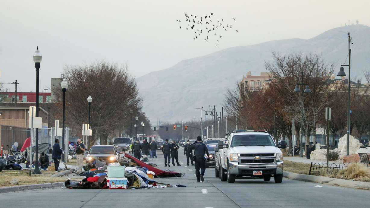 Salt Lake police officers patrol as Salt Lake County Health Department workers clean up homeless encampments on 500 West and 400 South in Salt Lake City on Wednesday, Dec. 9, 2020. According to the department, the cleanup is part of the the department’s “routine operations” that occur about once a week.