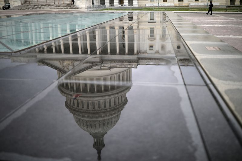 FILE PHOTO: The U.S. Capitol Building is reflected on a marble seating area following a rainstorm at the East Front on Capitol Hill in Washington, U.S., December 4, 2020. REUTERS/Tom Brenner