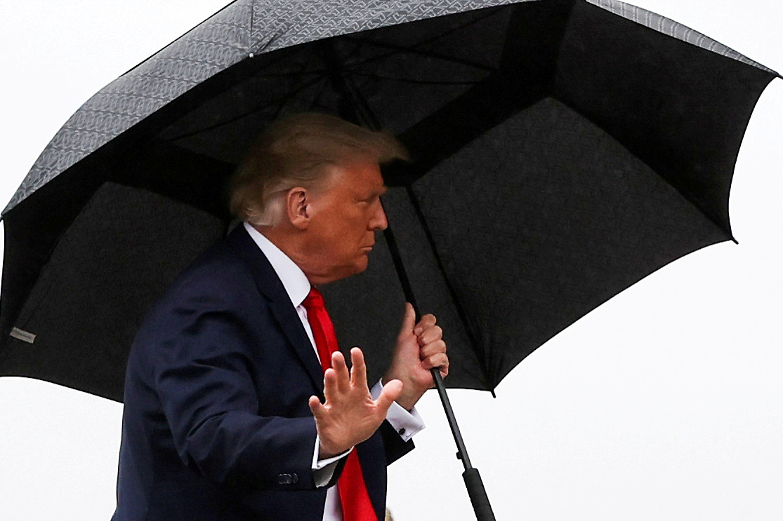 FILE PHOTO: U.S. President Donald Trump carries an umbrella while boarding Air Force One at Joint Base Andrews, Maryland, U.S., October 12, 2020. REUTERS/Jonathan Ernst/File Photo