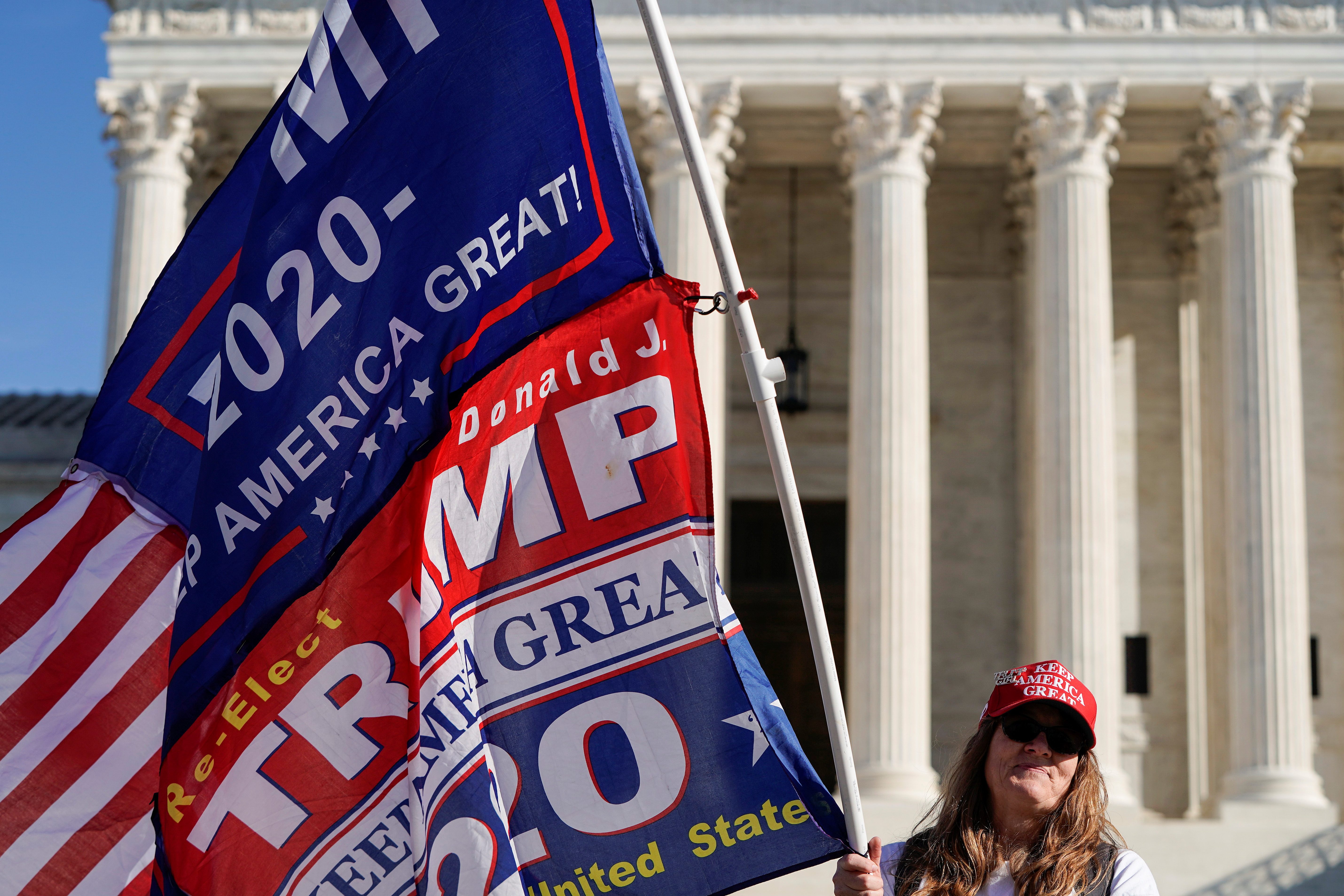 Kathleen Kratt, of Orlando, Florida, and a supporter of U.S. President Donald Trump holds a flag in front of the Supreme Court as the court reviews a lawsuit filed by Texas seeking to undo President-elect Joe Biden's election victory in Washington, U.S., December 11, 2020.