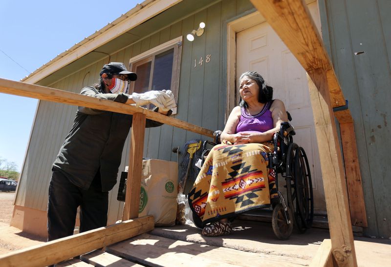 Pete Sands, Utah Navajo COVID-19 Relief program project
manager, chats with Mary Lou Clark after delivering food to her
outside of her home in Halchita, San Juan County, on Wednesday,
April 29, 2020. The Navajo Nation has one of the highest per capita
COVID-19 infection rates in the country.