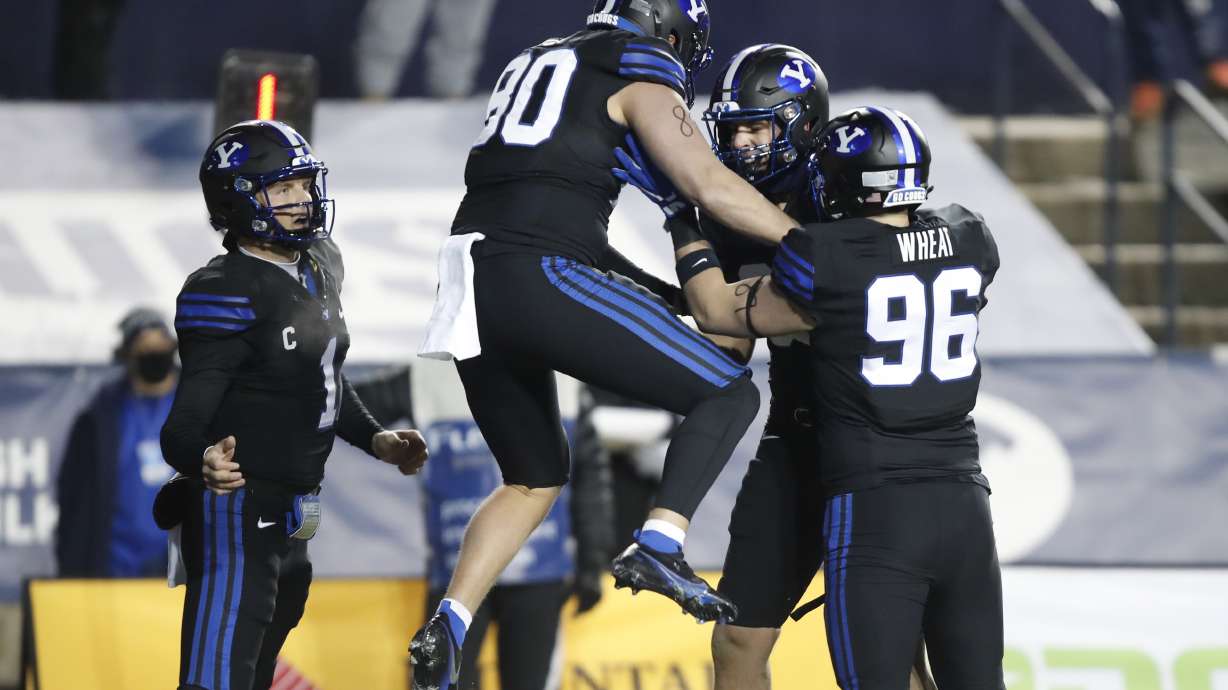 BYU quarterback Zach Wilson (1), tight end Lane Lunt (80) , BYU tight end Carter Wheat (96) and a teammate celebrate a touchdown in the first half of an NCAA college football game against San Diego State Saturday, Dec. 12, 2020, in Provo, Utah. (AP Photo/George Frey, Pool)