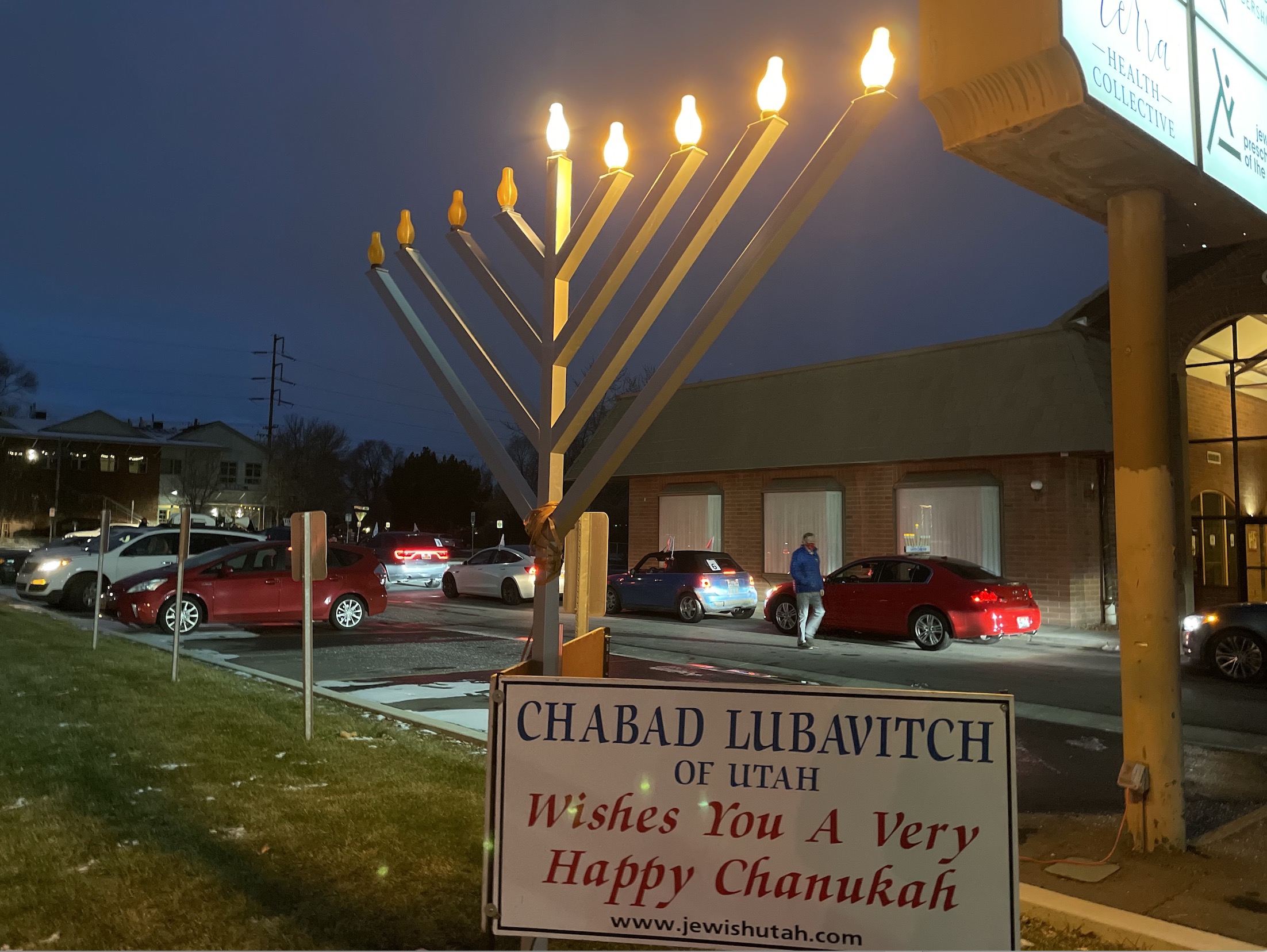 The menorah at Chabad Lubavitch of Utah shines bright as cars prepare to leave for the first-ever car menorah parade to celebrate the fourth night of Hanukkah on Sunday, Dec. 13, 2020.