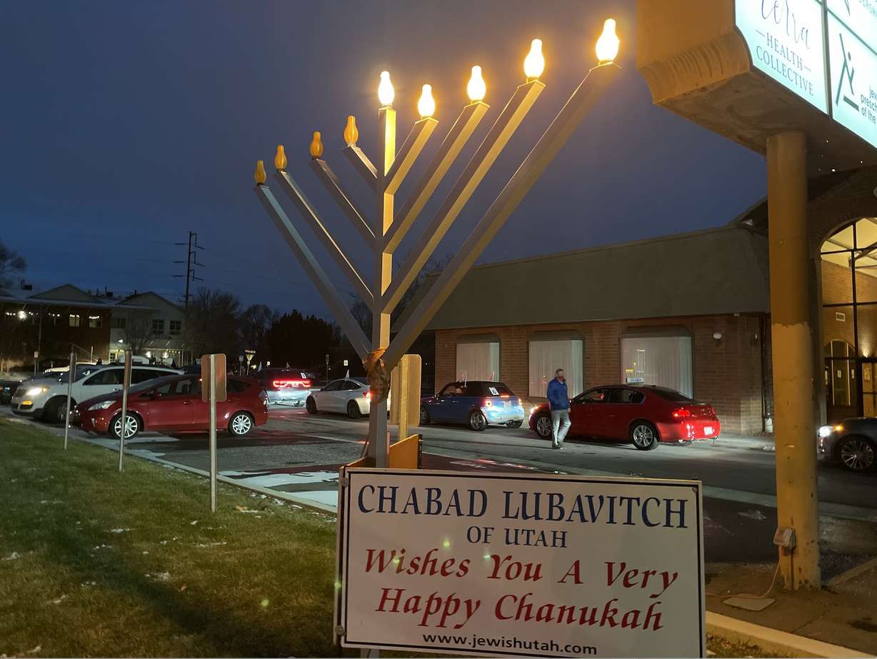 The menorah at Chabad Lubavitch of Utah shines bright as cars prepare to leave for the first-ever car menorah parade to celebrate the fourth night of Hanukkah on Sunday, Dec. 13, 2020.