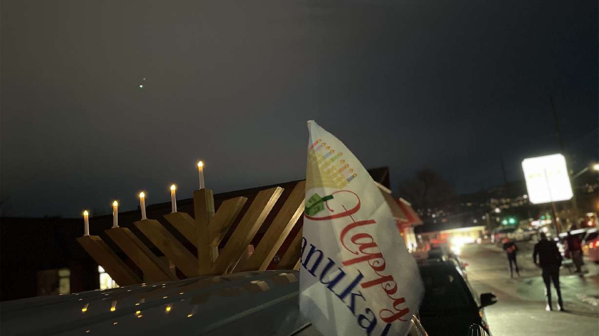A "Happy Chanukah" flag is seen blowing in the wind as cars prepare to drive in Chabad Lubavitch of Utah's first-ever car menorah parade to celebrate the fourth night of Hanukkah on Sunday, Dec. 13, 2020.