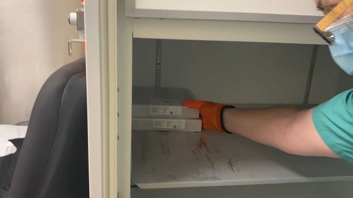 Workers at Utah Valley Hospital in Provo place the first two boxes of the Pfizer/BioNTech COVID-19 vaccine into a freezer at the hospital. The two boxes contain about 2,000 doses of the vaccine and are expected to be first administered on Wednesday, Dec. 16, 2020.