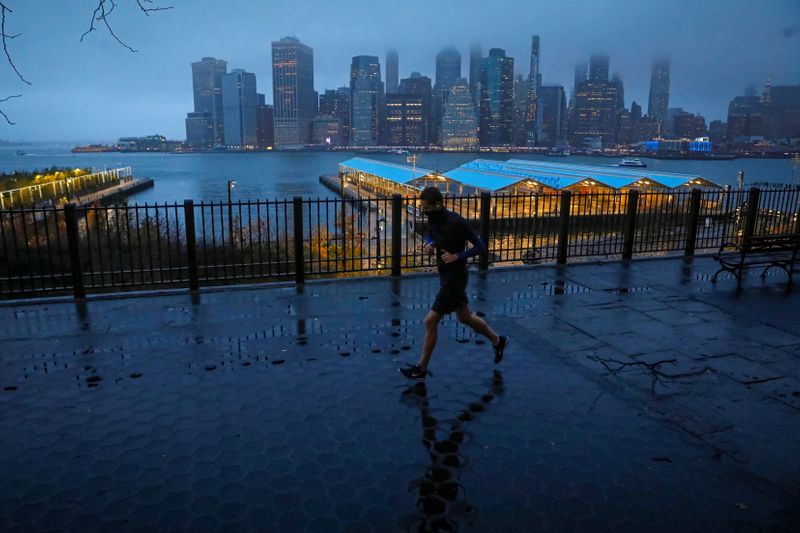 FILE PHOTO: A man runs along the Brooklyn Heights Promenade as fog covers lower Manhattan in New York, U.S. November 30, 2020.  REUTERS/Brendan McDermid
