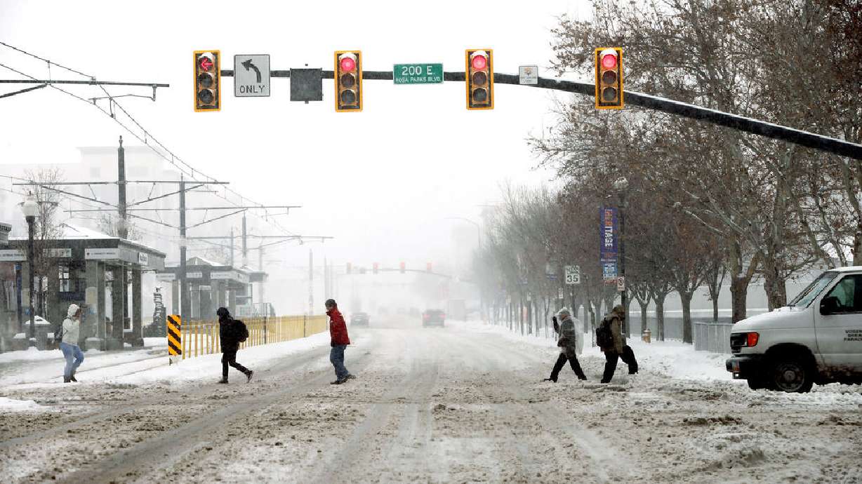 Pedestrians cross 400 South at 200 East in Salt Lake City on Monday, Feb. 3, 2020. A major snowstorm hit the area Monday, snarling traffic and forcing the closure of many businesses and schools.