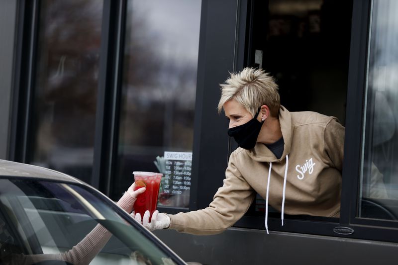 Breast cancer survivor Nicole Tanner, founder of drink
company Swig, helps a customer at her newest location in West
Jordan on Wednesday, Dec. 16, 2020. Tanner raises money to help
other women who need surgery and can’t afford to pay for it
themselves. Eleven years ago, Tanner’s surgery was paid for by an
anonymous donor.