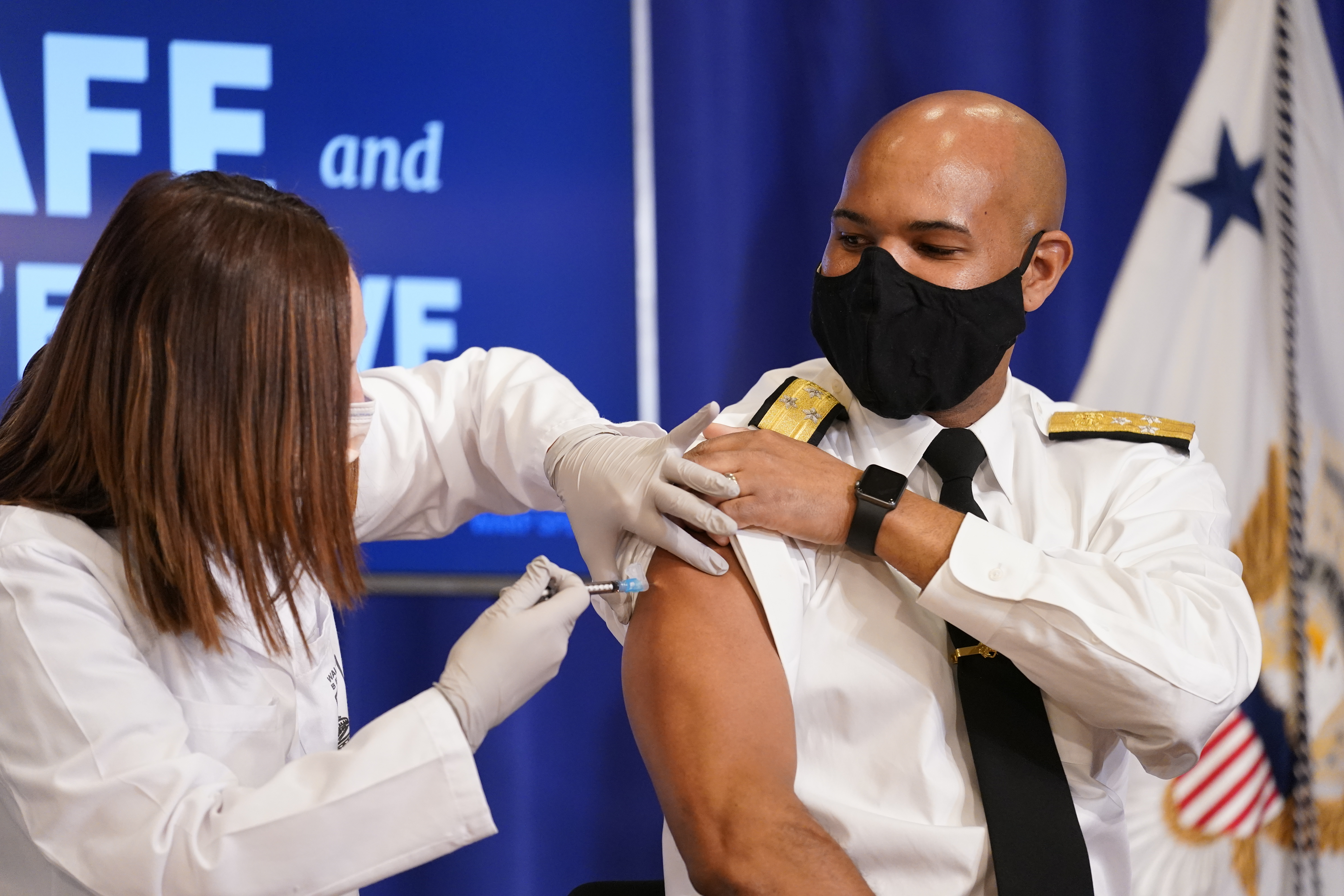 U.S. Surgeon General Jerome Adams receives a Pfizer-BioNTech COVID-19 vaccine shot at the Eisenhower Executive Office Building on the White House complex, Friday, Dec. 18, 2020, in Washington.  Vice President Mike Pence, his wife Karen Pence also participated. (AP Photo/Andrew Harnik) [Dec-18-2020]