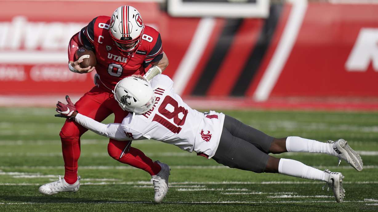Washington State defensive back George Hicks III (18) tackles Utah quarterback Jake Bentley (8) during the first half of an NCAA college football game Saturday, Dec. 19, 2020, in Salt Lake City. (AP Photo/Rick Bowmer)