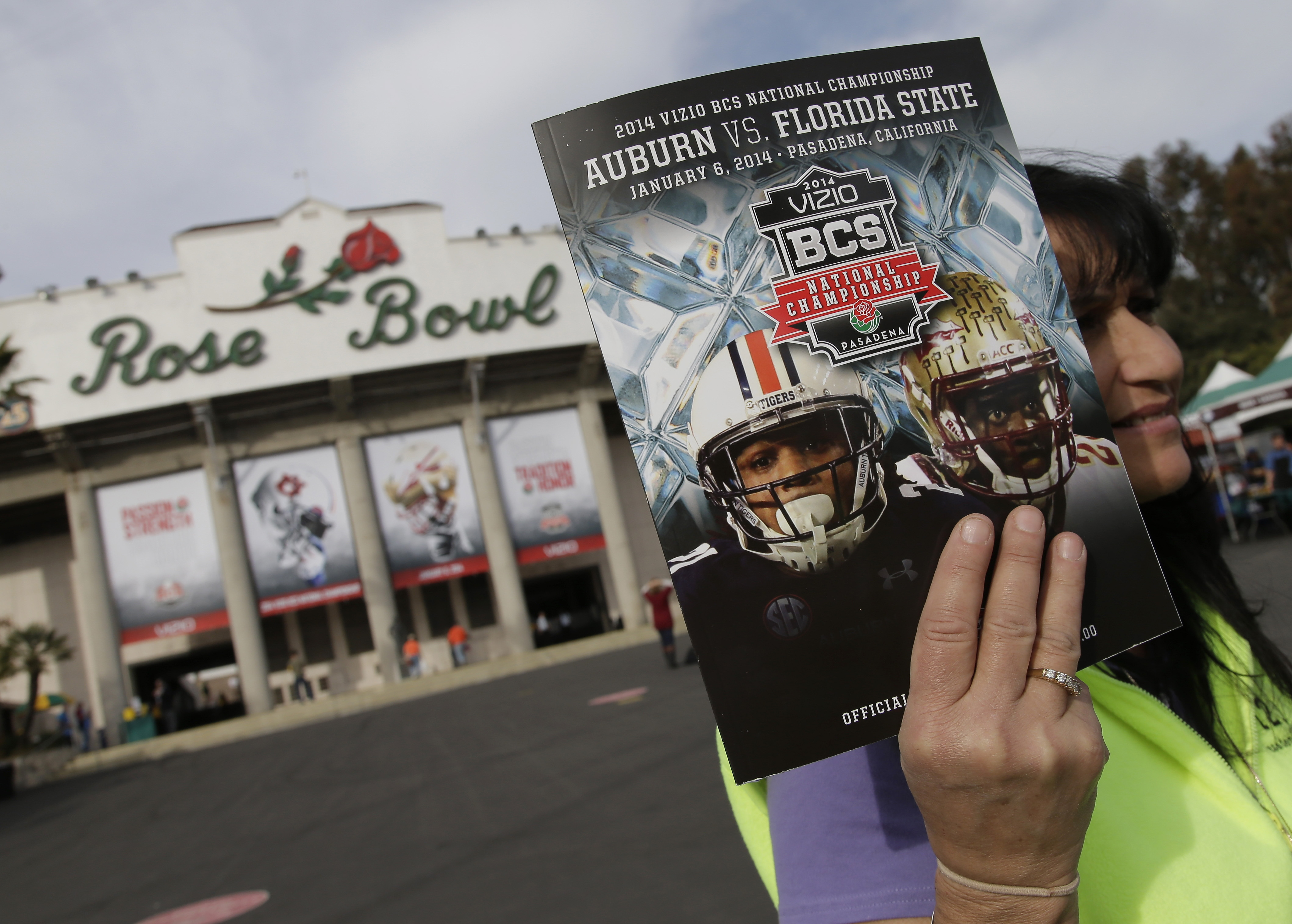 In this Jan. 6, 2014, file photo, a vendor sells a program outside the Rose Bowl before the BCS National Championship NCAA college football game between Auburn and Florida State in Pasadena, Calif. The Rose Bowl was denied a special exemption from the state of California to allow a few hundred fans to attend the College Football Playoff semifinal on Jan. 1, putting the game staying in Pasadena in serious doubt.  A person involved with organizing the game told The Associated Press the Tournament of Roses' request was denied earlier this week.