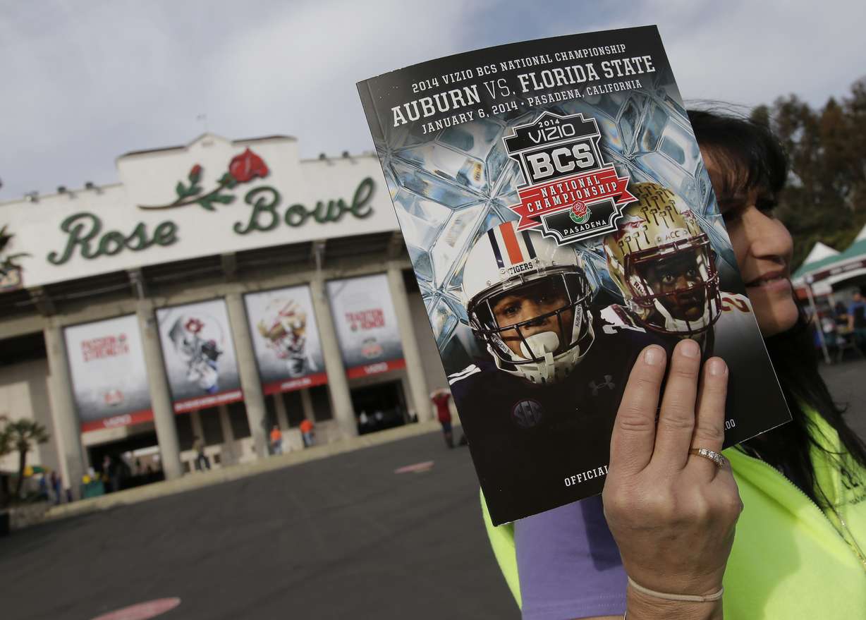 In this Jan. 6, 2014, file photo, a vendor sells a program outside the Rose Bowl before the BCS National Championship NCAA college football game between Auburn and Florida State in Pasadena, Calif. The Rose Bowl was denied a special exemption from the state of California to allow a few hundred fans to attend the College Football Playoff semifinal on Jan. 1, putting the game staying in Pasadena in serious doubt. A person involved with organizing the game told The Associated Press the Tournament of Roses' request was denied earlier this week.