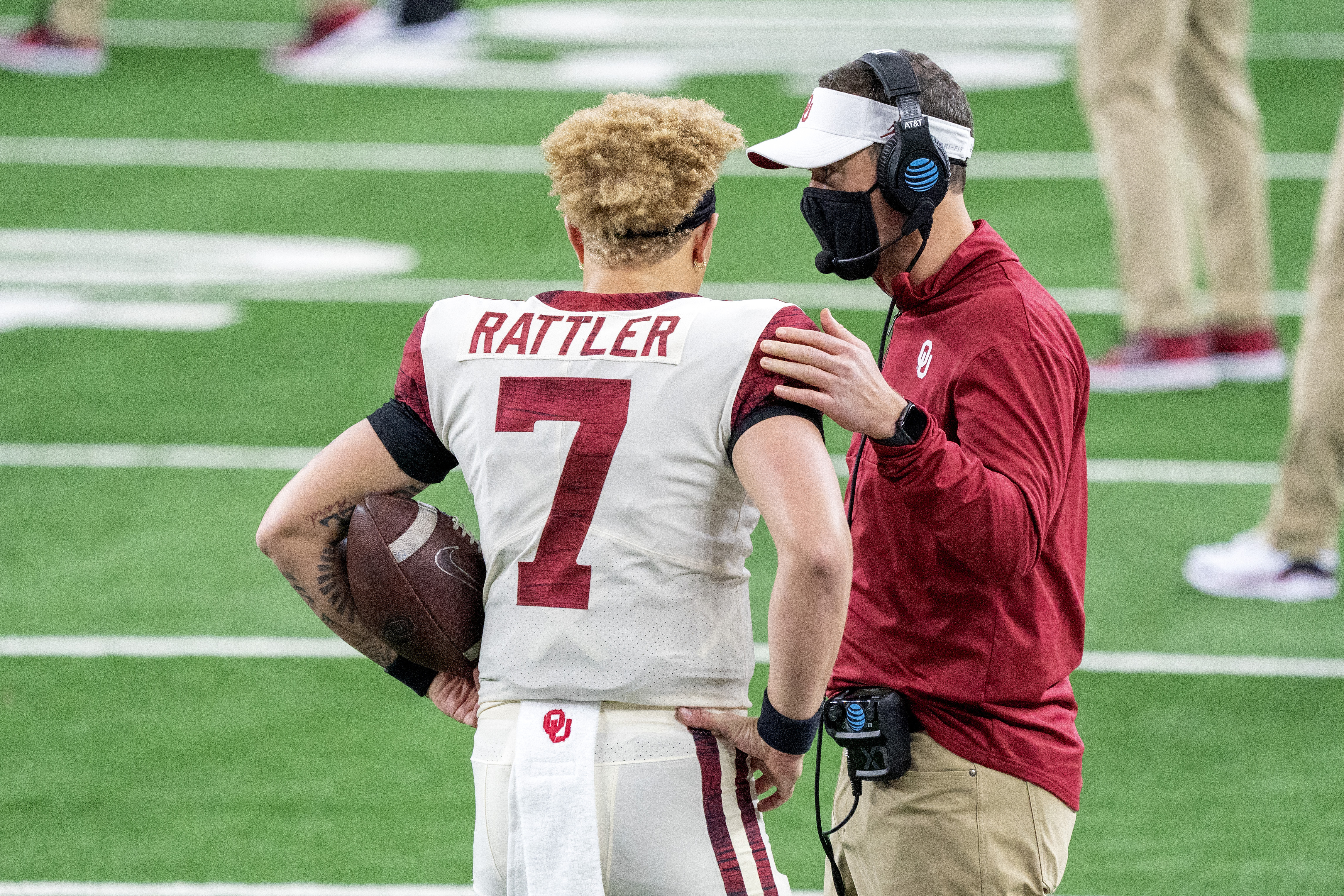 Oklahoma head coach Lincoln Riley talks with quarterback Spencer Rattler (7) before the Big 12 Conference championship NCAA college football game against Iowa State, Saturday, Dec. 19, 2020, in Arlington, Texas.