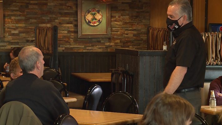 Manuel Gallegos Jr. visits with diners at his restaurant.