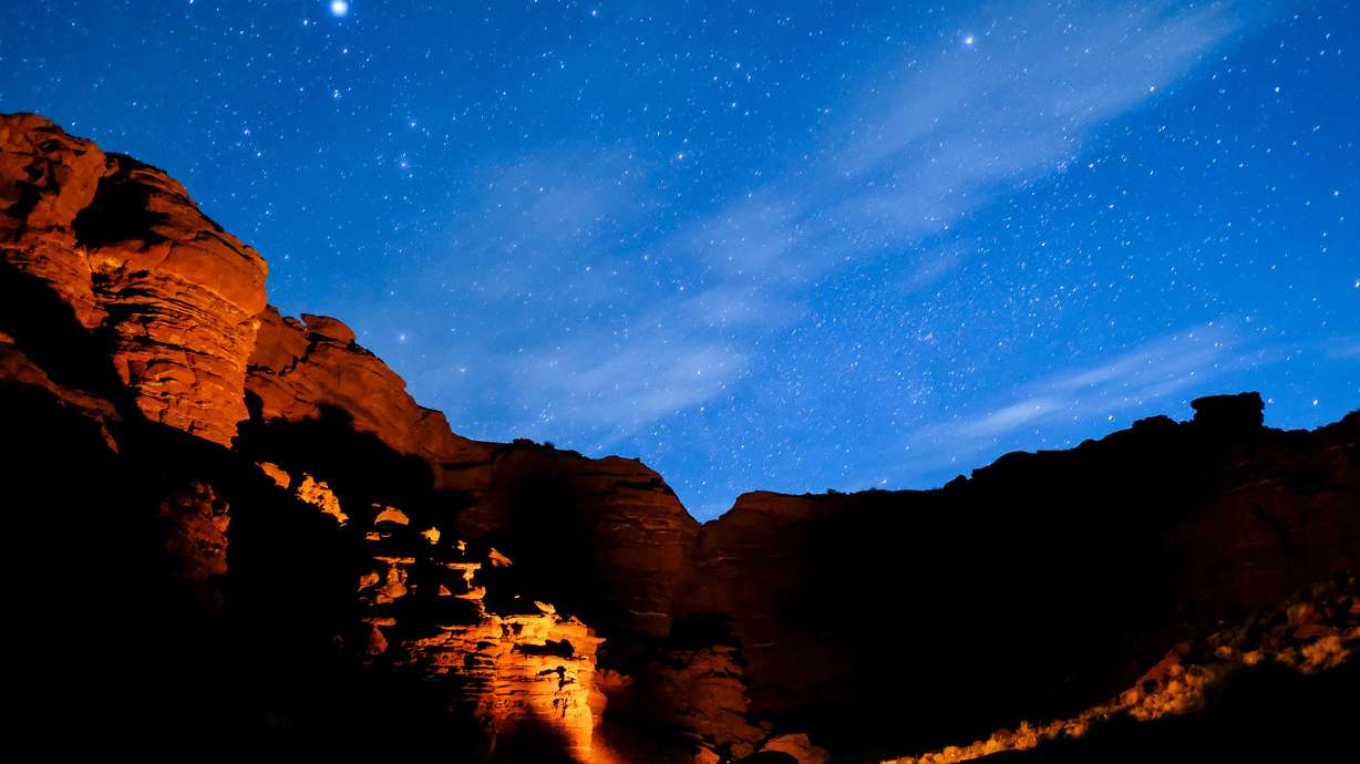 A campfire illuminates the surroundings under a starry sky in Lockhart Basin in San Juan County on Sunday, May 14, 2017.