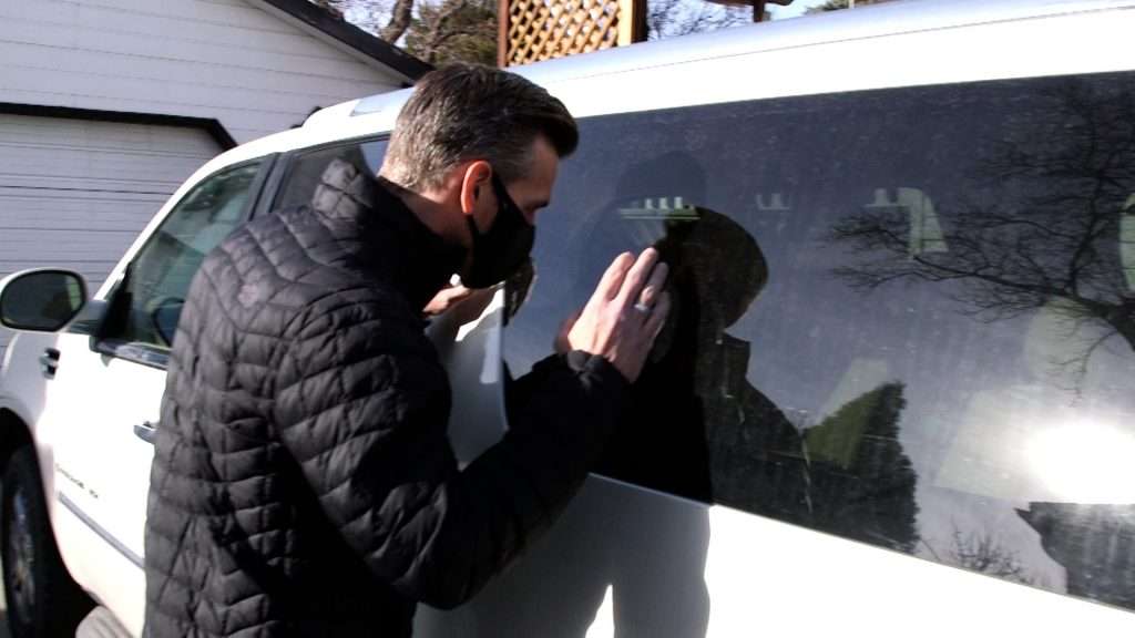 KSL Investigator Mike Headrick looks in the windows of a stolen SUV.