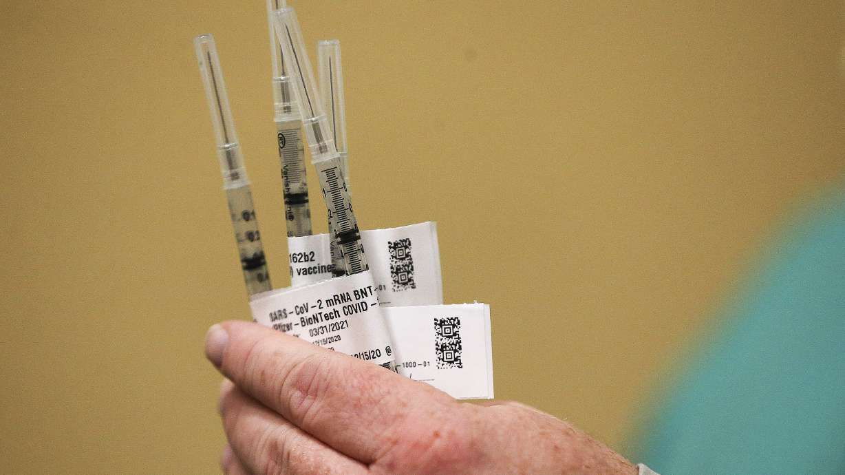 LDS Hospital pharmacy director Robb Dengg holds the first COVID-19 vaccines for hospital employees at the hospital in Salt Lake City on Tuesday, Dec. 15, 2020.