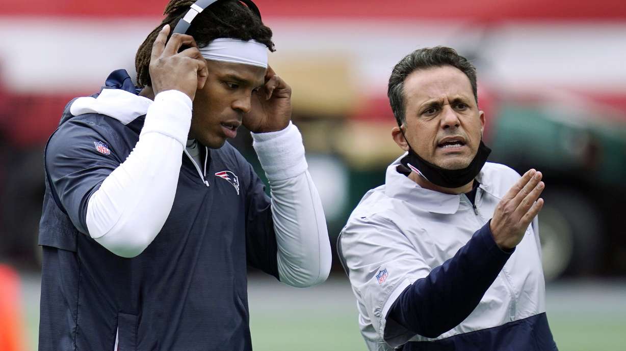 Former New England Patriots quarterback Cam Newton, left, stands beside quarterback coach Jedd Fisch before an NFL football game against the San Francisco 49ers in Foxborough, Mass.