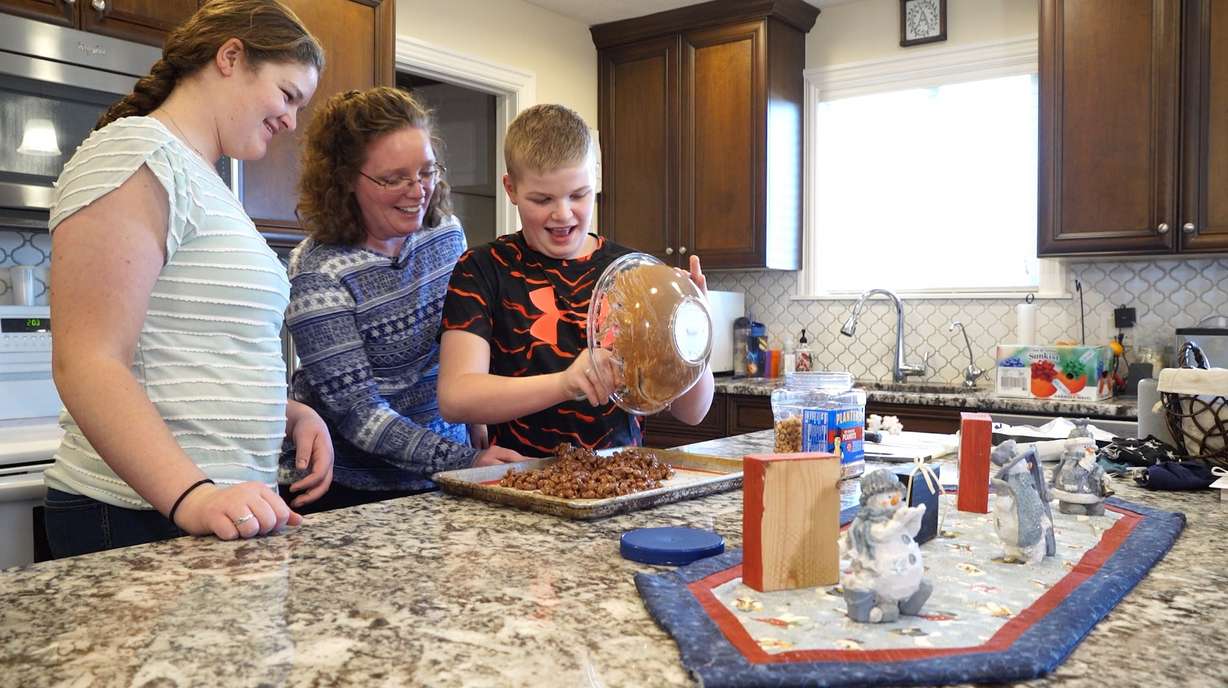 Angelina makes peanut clusters for their neighbors and friends with two of her four children, Abagail and Wyatt.