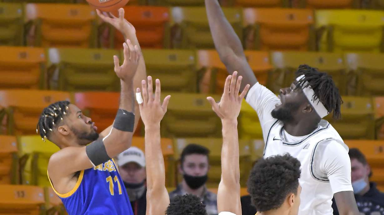 San Jose State guard Richard Washington (11) shoots as Utah State guard Marco Anthony (44) and center Neemias Queta defend during the first half of an NCAA college basketball game Wednesday, Dec. 23, 2020, in Logan, Utah. (Eli Lucero/The Herald Journal via AP, Pool)